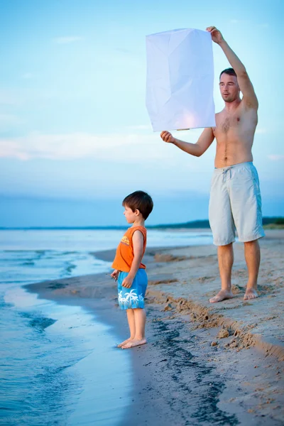 Happy dad and son flying fire lantern together — Stock Photo, Image