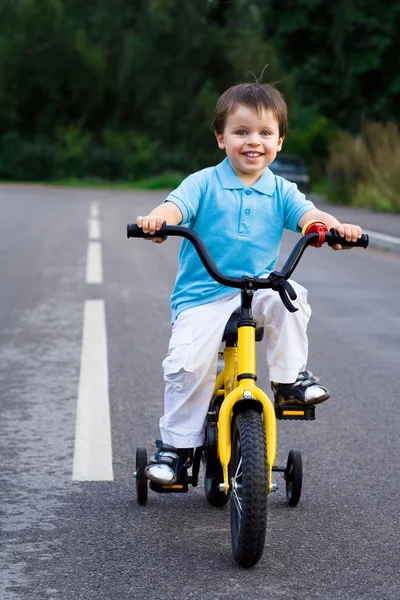 Маленький велосипедист в туре по дороге — стоковое фото