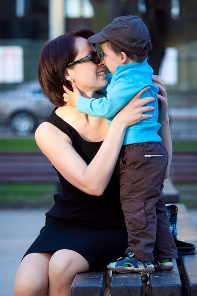 Любящие мать и сын обнимаются на открытом воздухе — стоковое фото