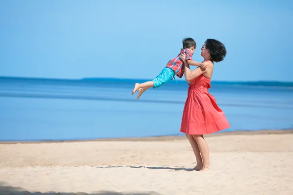 Mãe e seu filho brincando na praia — Fotografia de Stock