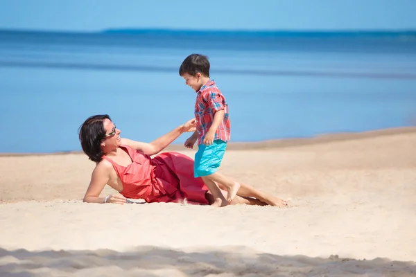 Anne ve küçük oğlu kumsalda oynarken — Stok fotoğraf