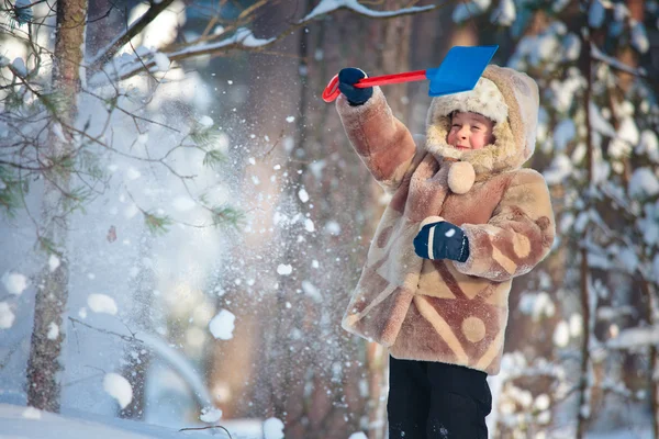 Porträtt av en liten pojke som leker utomhus i en vinter skog — Stockfoto