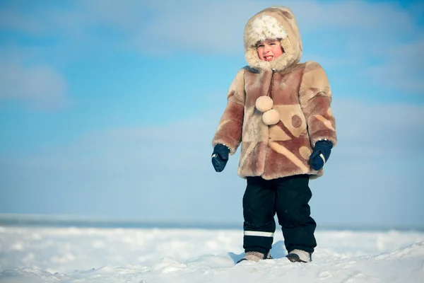 Portrait of a little boy on holiday standing on winter beach — Zdjęcie stockowe