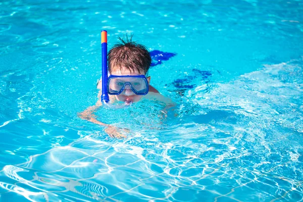 En liten pojke i en pool med simning mask och snorkel — Stockfoto