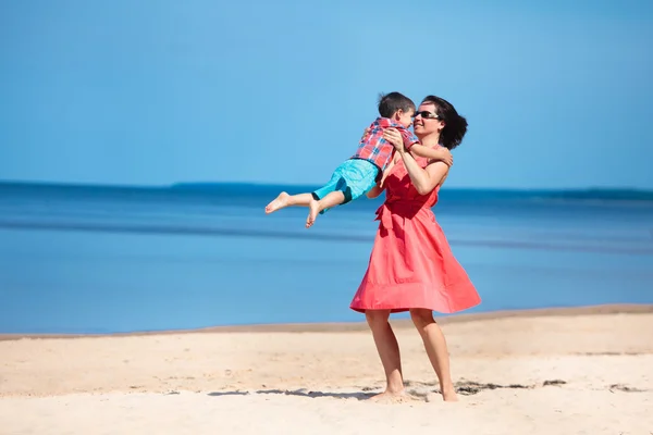 Mãe e seu filho brincando na praia — Fotografia de Stock