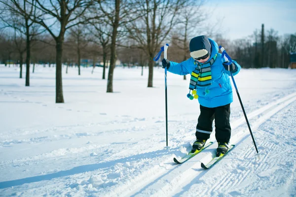 Милый маленький мальчик катается на лыжах на кресте — стоковое фото