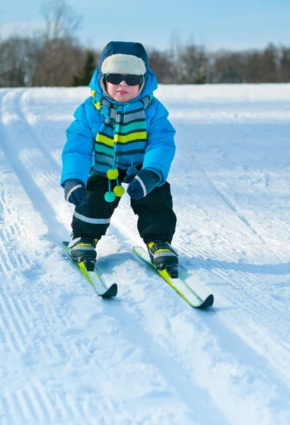 Lindo niño esquiando cuesta abajo — Foto de Stock
