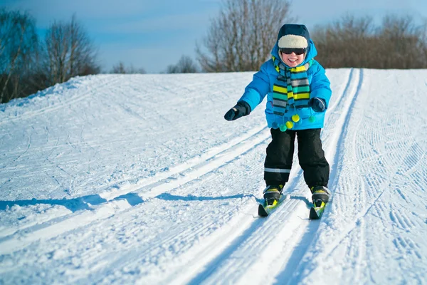 Lindo niño esquiando cuesta abajo — Foto de Stock