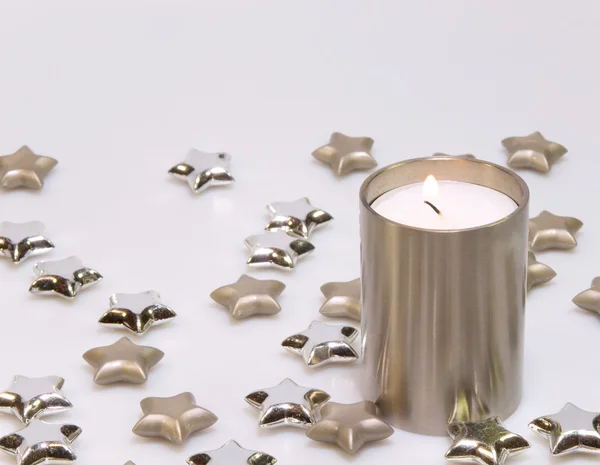 Dekorace z hořící svíčku a hvězdy ve stříbře — Stock fotografie
