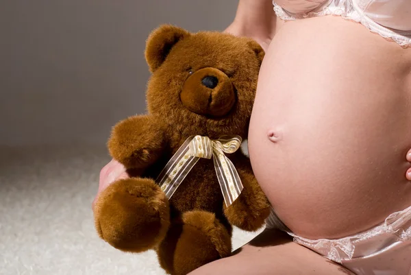 Pregnant belly with Teddy bear — Stock Photo, Image