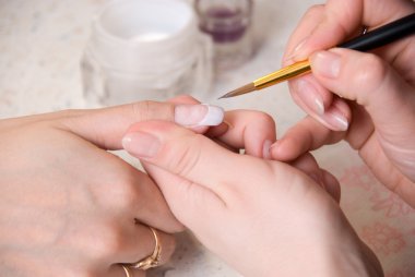 Manicurist treating client at beauty salon clipart