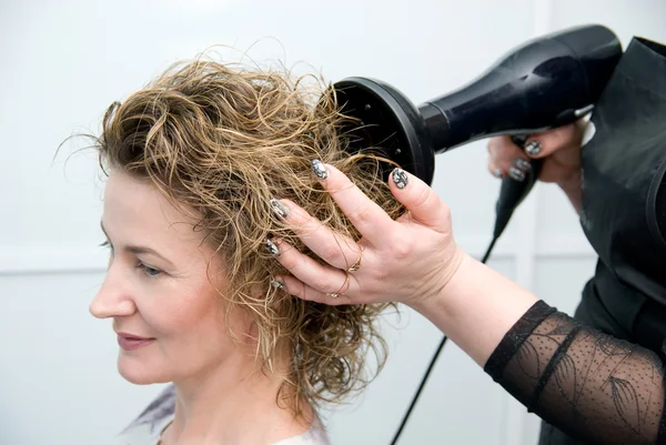 Stylist secagem mulher cabelo — Fotografia de Stock