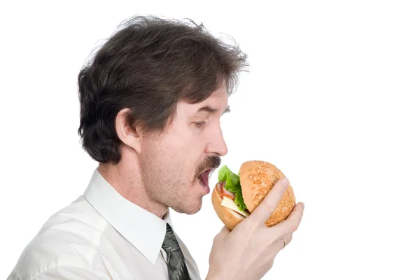Man with moustache eats hamburger — Stock Photo, Image