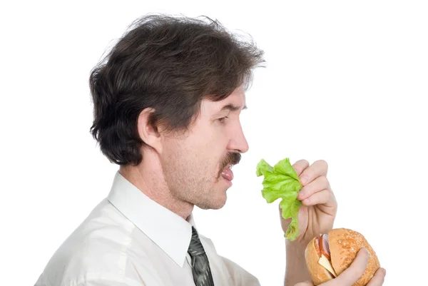 Homem vai começar a partir de salada de hambúrguer folha e come — Fotografia de Stock