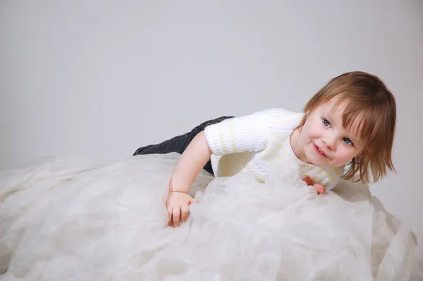 Il bel bambino sdraiato su un tessuto leggero — Foto Stock