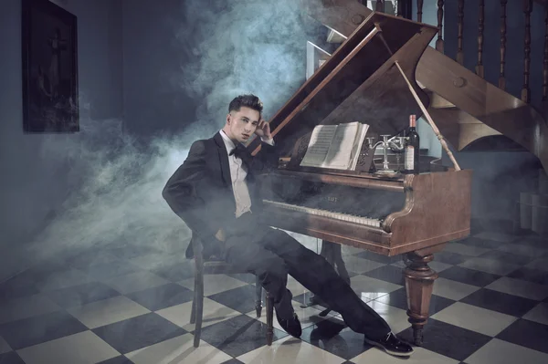Элегантный молодой человек с фортепиано — стоковое фото
