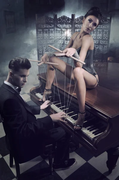 Sensuele vrouw in sexy lingerie zittend op een piano Stockafbeelding