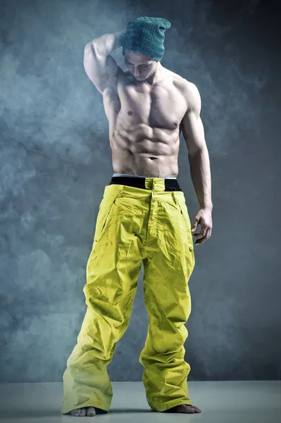 Homem muscular em uma pose de moda em trausers de snowboard — Fotografia de Stock
