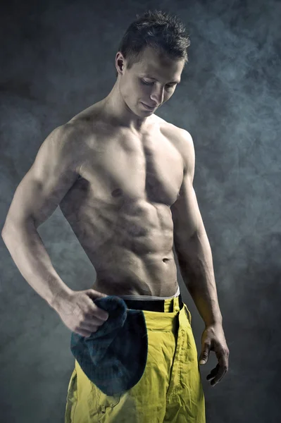 Homem muscular em uma pose de moda com boné — Fotografia de Stock