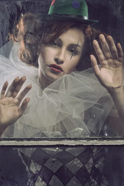 Sad Pierrot woman behind the glass — Stock Photo, Image