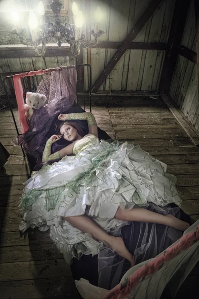 Mulheres de beleza em vestido deitado na cama — Fotografia de Stock