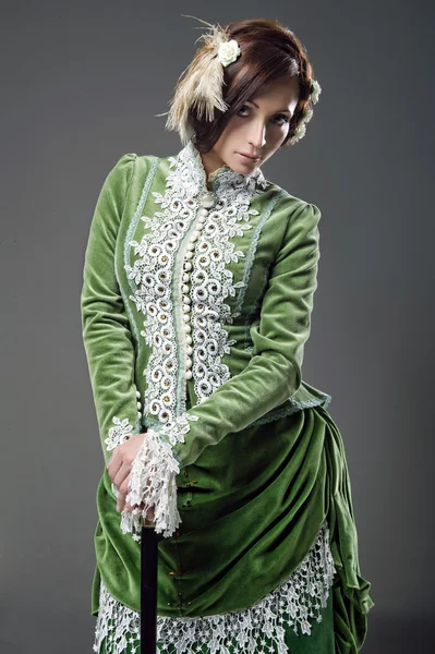 Morena delicada com bengala posando em um vestido vintage — Fotografia de Stock