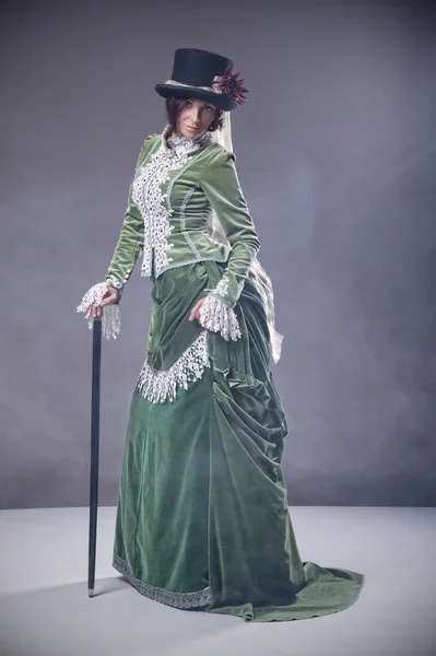 Femme de beauté avec bâton de marche portant une robe à l'ancienne — Photo