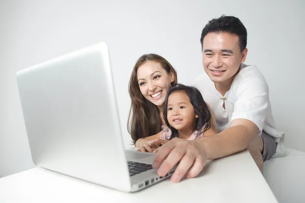 Азиатская семья с ноутбуком — стоковое фото