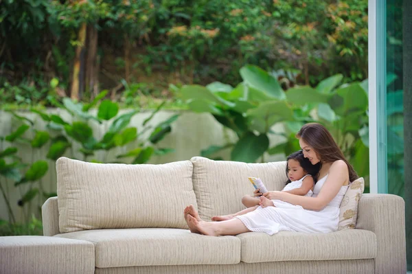 Madre enseñando a la hija a leer — Foto de Stock