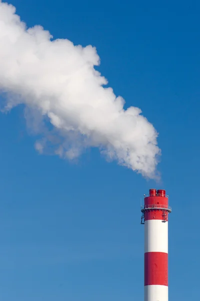 Промисловий димохід з великою кількістю диму на блакитному небі — стокове фото