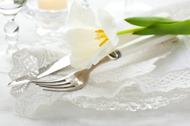 Place-setting with white tulip and napkin clipart