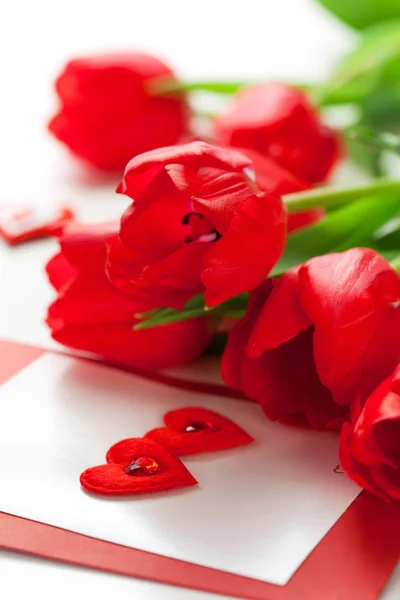 Tulipanes rojos y tarjeta de felicitación — Foto de Stock