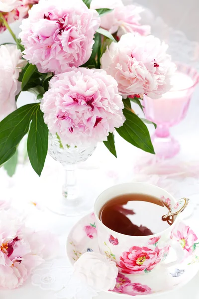 Różowe piwonie i filiżankę herbaty — Zdjęcie stockowe
