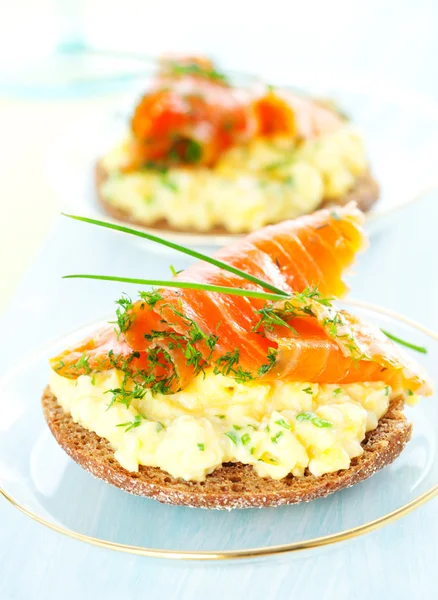 Toast with scrambled eggs,salmon and chives — Stock Photo, Image