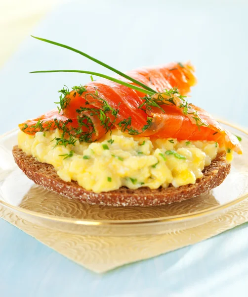 Toast with scrambled eggs,salmon and chives — Stock Photo, Image