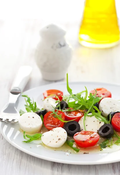 Салат с моцареллой, помидорами и черной оливкой — стоковое фото