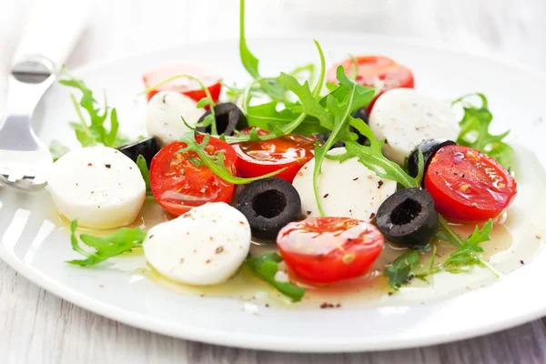 Salad with mozzarella, tomatoes and black olive — Stock Photo, Image