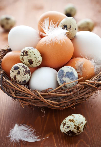 Jaja w gnieździe na drewnianym stole — Zdjęcie stockowe