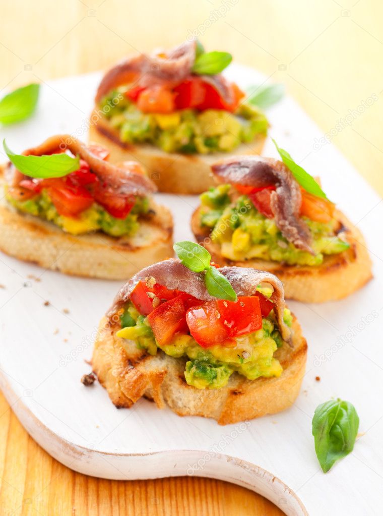 Crostini with avocado,tomato and anchovy