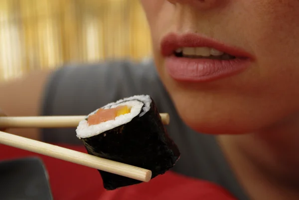 年轻漂亮的女人吃寿司卷 — 图库照片
