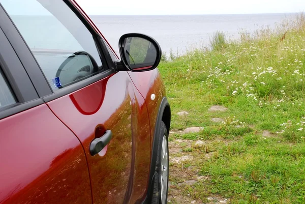 Carro vermelho em uma costa do mar — Fotografia de Stock