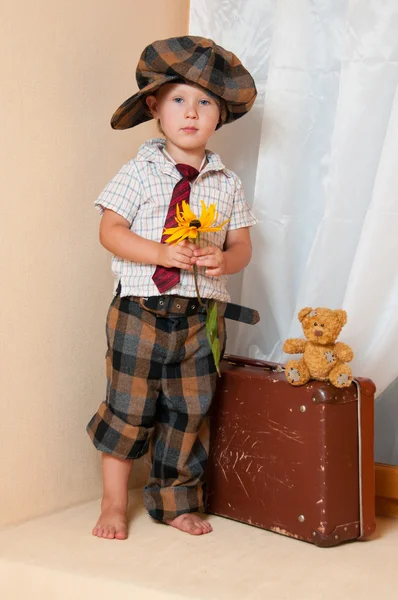 花的可爱小男孩。他戴着帽子. — 图库照片