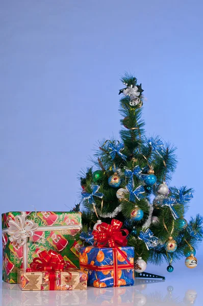 Los regalos de Año Nuevo en el embalaje de fiesta bajo el árbol . — Foto de Stock