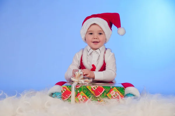 Grappige laughing baby in santa pak met een huidige doos. — Stockfoto