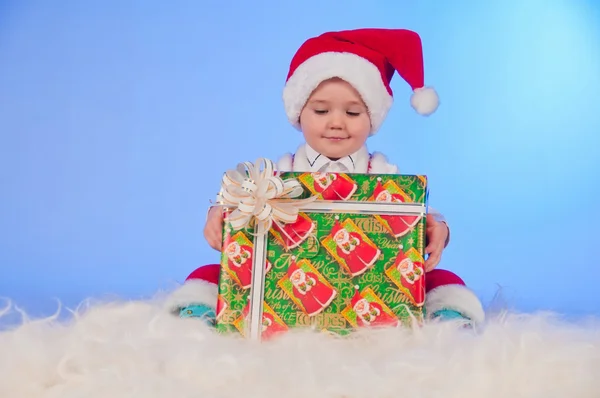Funny laughing baby in Santa suit with a present box. — Stock Photo, Image