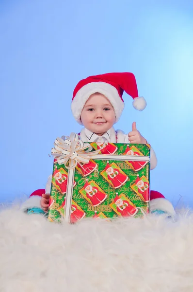 Divertente bambino ridente in costume da Babbo Natale con una scatola regalo . — Foto Stock