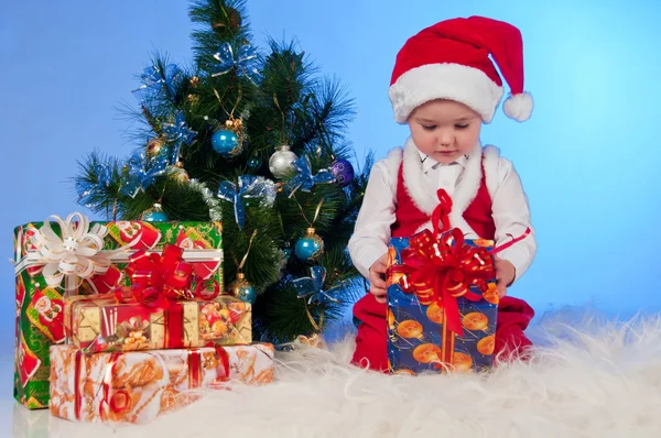 Funny laughing baby in Santa suit with a present box. — Stock Photo, Image