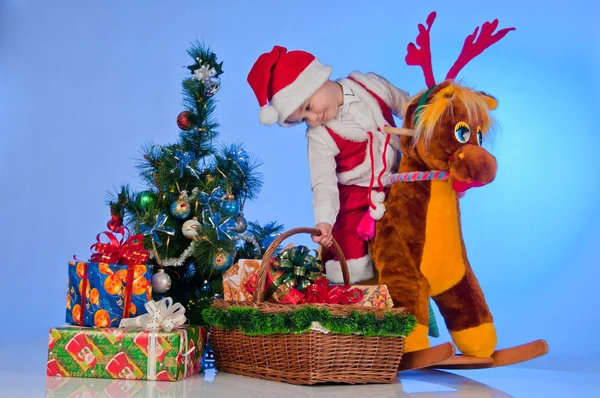 Santa's Little Helper. An adorable baby Santa on his reindeer near the — Stock Photo, Image