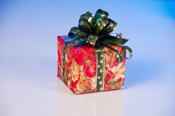El regalo de Año Nuevo en el embalaje de fiesta. Caja roja con cinta verde . — Foto de Stock