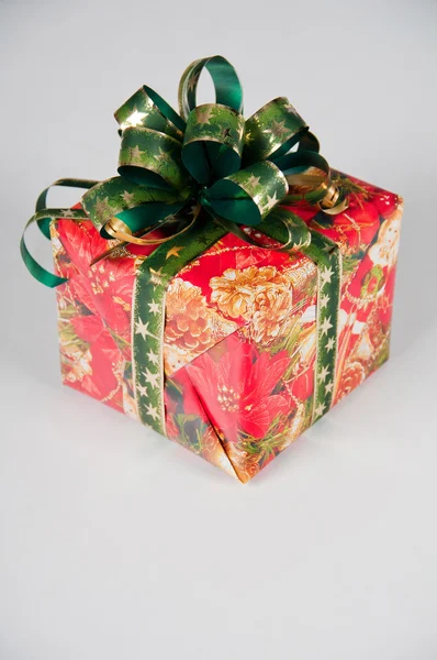 El regalo de Año Nuevo en el embalaje de fiesta. Caja roja con cinta verde . — Foto de Stock
